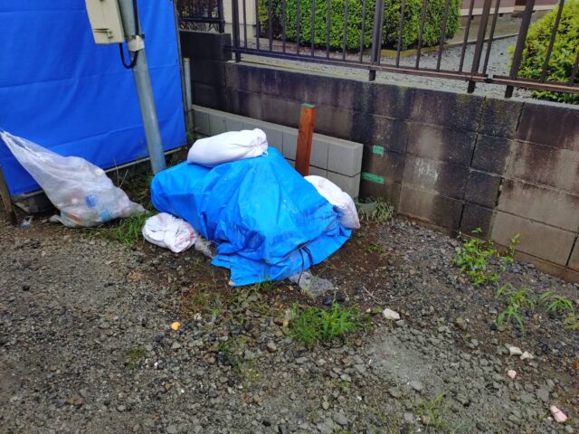 入間市の注文住宅新築工事現場で、産廃回収後に青いシートの手前の地面が見えるようになった置き場