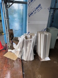 新座市の戸建て新築工事現場で、回収前に石膏ボードの端材と廃材袋が置かれた屋外の保管場所