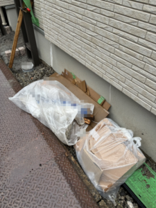足立区千住の産廃回収前。戸建て新築工事現場の建物脇にまとめられた混合廃棄物と養生材