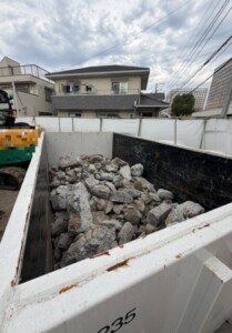 福生市の施設の新築現場で、仮囲いの内側に置いたコンテナにコンクリートガラを積んだ様子