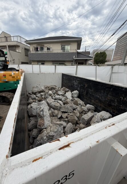 福生市の施設の新築現場で、仮囲いの内側に置いたコンテナにコンクリートガラを積んだ様子