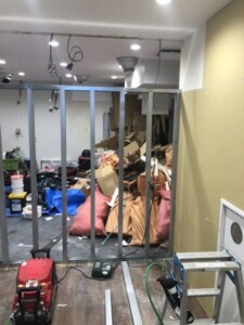 横浜市中区の店舗リフォーム現場で、室内に集積された袋詰めの廃材やダンボールなど