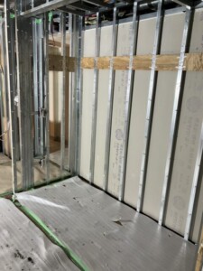 廃棄物の搬出後、軽量鉄骨の下地と床の養生が見えるマンション室内