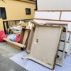 回収前の様子。ユニットバスのパネルや洗面台、木材、袋詰めの廃材が、養生材の上に仮置きされていました。