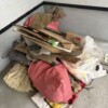 小金井市の住宅新築現場のガレージに、手直し工事で出た段ボールや板材、袋詰めの廃材が積まれている様子