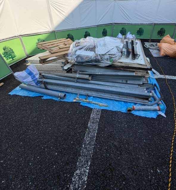 練馬区の受水タンク工事で出た木製パレットや金属部材、配管がまとめて置かれている様子