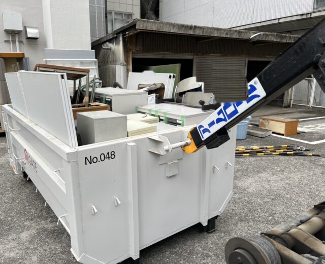 さいたま市の事務所改修で出たスチール机やキャビネット、パーティションを3tコンテナ車のコンテナに積み込んでいる様子